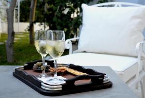 two glasses of wine and snacks on a tray on a table at VILLA EDO in Gammarth