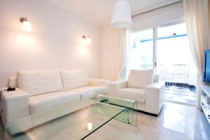 a living room with a white couch and a glass coffee table at Terrazas de Banus in Marbella