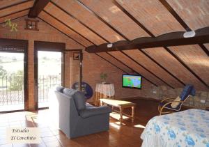salon z krzesłem i telewizorem w obiekcie Apartamentos Rurales Monfragüe w mieście Torrejón el Rubio