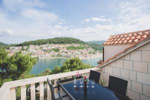 a table on a balcony with a view of the water at Apartmani Bauk in Pučišća