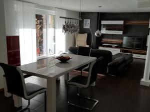 a kitchen and living room with a table and chairs at Ferienwohnung Lechraum in Waal in Waal