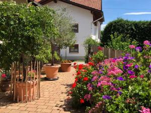 a garden with colorful flowers and a fence at Ferienwohnung Lechraum in Waal in Waal