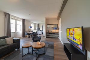 a living room with a couch and a tv at Raadhuis Parc Ganuenta in Colijnsplaat