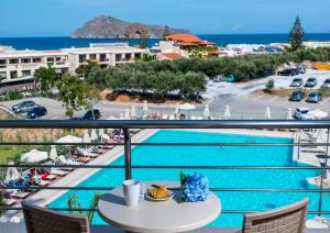 a view of a pool from a hotel balcony at Porto Platanias Village Resort in Plataniás
