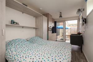 1 dormitorio con cama y vistas a un balcón en Studio's Westkapelle Willebrordstraat 13, en Westkapelle