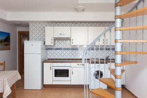 a kitchen with white cabinets and a staircase at TAO El Cotillo - VV in El Cotillo