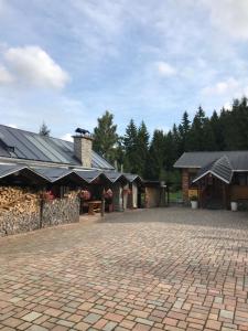 a brick courtyard with a building with a stone wall at Penzion Trampska Bouda in Abertamy