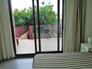 a bedroom with a sliding glass door to a balcony at Aparthotel El Faro in Cullera