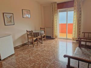 a living room with a table and chairs and a window at Hotel Las Vegas in Cangas de Morrazo