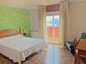 a bedroom with a bed and a window with a view at Hotel Las Vegas in Cangas de Morrazo