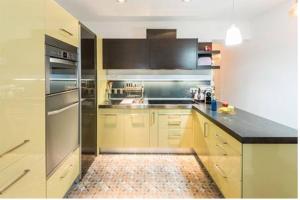 uma cozinha com armários amarelos e electrodomésticos de aço inoxidável em Visitor's Book em Madri