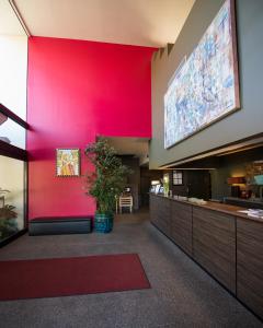 a lobby with a red wall and a large screen at Lemon Tree Inn in Santa Barbara