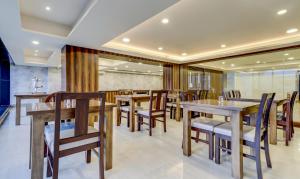 une salle à manger avec des tables et des chaises en bois dans l'établissement Treebo Trend Paul's Inn, à Bangalore