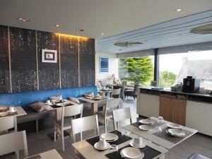 a dining room with tables and chairs in a restaurant at Logis Hôtel de Carantec in Carantec +55 photos