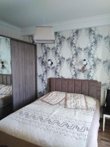 1 dormitorio con 1 cama y papel pintado con motivos florales en Apartment On Tavdadebuli en Batumi