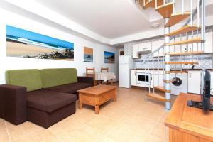 a living room with a couch and a kitchen at TAO El Cotillo in El Cotillo