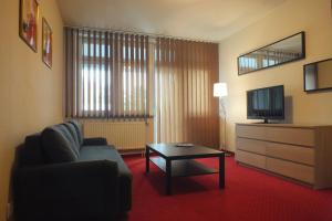 a living room with a couch and a tv and a table at Motel Subaru in Warsaw