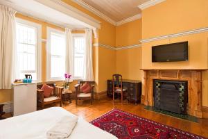 a bedroom with a fireplace and a tv on the wall at Fernando's the Grange in Port Elizabeth
