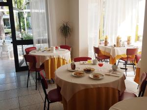a dining room with two tables with plates of food at Hotel Meris in Milano Marittima