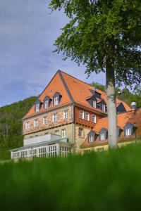 ein großes Gebäude mit einem Baum davor in der Unterkunft Sonnenresort Ettershaus in Bad Harzburg
