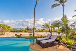 uma piscina de resort com 2 espreguiçadeiras e palmeiras em Hara Pousada e SPA em São Miguel do Gostoso
