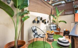eine Terrasse mit Stühlen, Pflanzen und einem Tisch in der Unterkunft Stay U-nique Apartments Ramón y Cajal in Barcelona