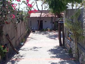 an alley with a house with a fence and flowers at Hospedagem da Keila Matos in Aracati