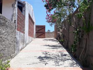 an alley with a fence and a gate and flowers at Hospedagem da Keila Matos in Aracati