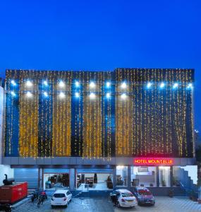 a building with cars parked in a parking lot at Trimrooms Mount Blue in Jaipur
