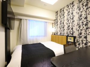 a bedroom with a bed and a window at APA Hotel Ochanomizu-Ekikita in Tokyo