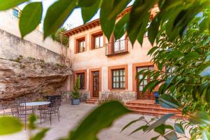 a building with a patio with chairs and a table at Hotel Spa Salinas de Imón in Imón