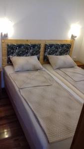 uma cama com duas almofadas em cima em Apartment Biser em Kotor