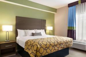 A bed or beds in a room at Baymont by Wyndham Ormond Beach