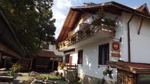 ein weißes Gebäude mit einem Balkon mit Blumen darauf in der Unterkunft Villa Filip in Bachevo