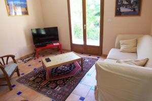 a living room with a couch and a tv and a table at Andre in Porto-Vecchio