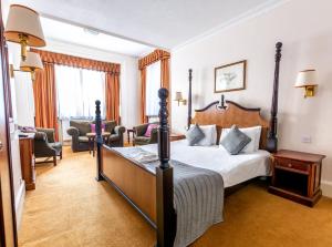 Habitación de hotel con cama y sala de estar. en North Stafford Hotel en Stoke on Trent