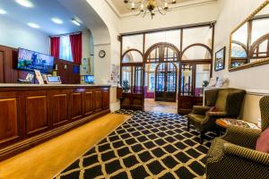 a lobby with a waiting area with chairs and a bar at North Stafford Hotel in Stoke on Trent