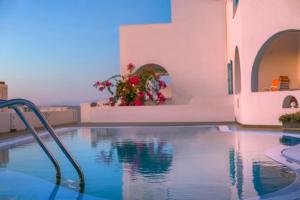 - une piscine dans une villa avec des fleurs en arrière-plan dans l'établissement Abelonas Retreat, à Imerovigli