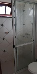 a shower with a glass door next to a toilet at Las Piedras del Paso in Paso de la Patria