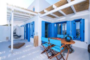 スキロスにあるAelia Collection Suites - Adults Friendlyの青い壁の客室で、木製のテーブルと椅子が備わります。