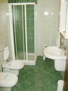 y baño con 2 aseos, ducha y lavamanos. en Albergo Corte Antica en Villafranca di Verona