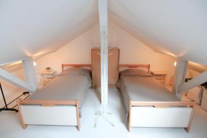 two beds in a attic room with a roof at Le Belvosgien in Gérardmer