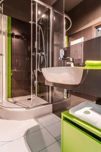 a bathroom with a sink and a shower at Apartamenty Grępielnia in Bielsko-Biała