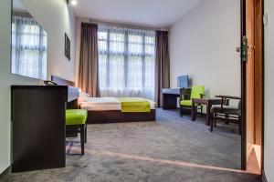 ein Hotelzimmer mit einem Bett, einem Tisch und Stühlen in der Unterkunft Apartamenty Grępielnia in Bielsko-Biała