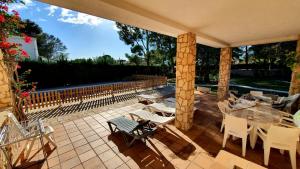 eine Terrasse mit einem Tisch, Stühlen und einem Zaun in der Unterkunft Villa Bella Cala in L'Ametlla de Mar