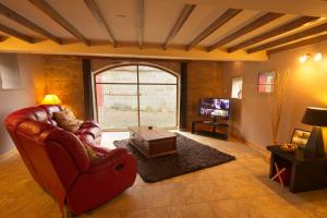 a living room with a red couch and a tv at Spangle Cottage, Borrowby Farm Cottages in Staithes