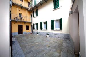 a courtyard of a building with two potted plants at Lakefront Cadorna Apartment - Affitti Brevi italia in Lecco