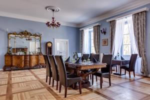 comedor con paredes azules y mesa y sillas de madera en Talaria Resort&Spa, en Trojanów