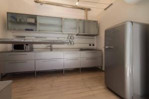 uma cozinha com armários brancos e um frigorífico de aço inoxidável em Lungolago Holiday Home - Affitti Brevi Italia em Lecco