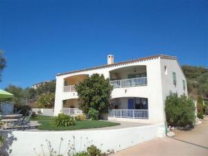 a large white building with a tree in front of it at Résidence U MELU Grand T2 BLEU en rez de jardin in Tiuccia